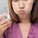 Person gently pressing a loose tooth while using a clean cloth for home dental care